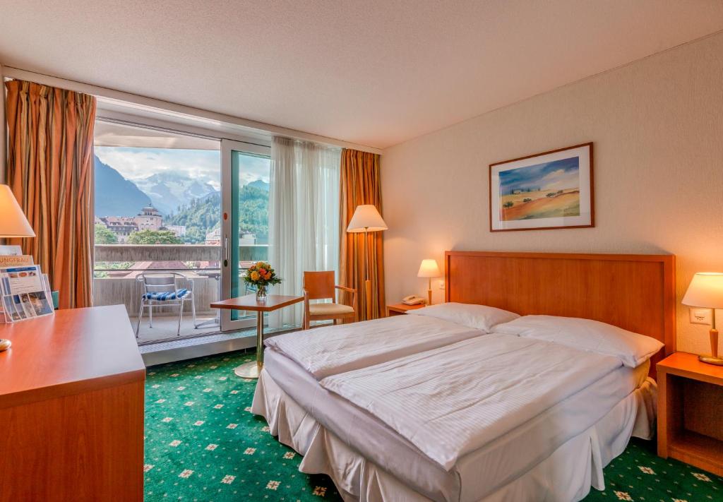 Postel nebo postele na pokoji v ubytování Hotel Metropole Interlaken