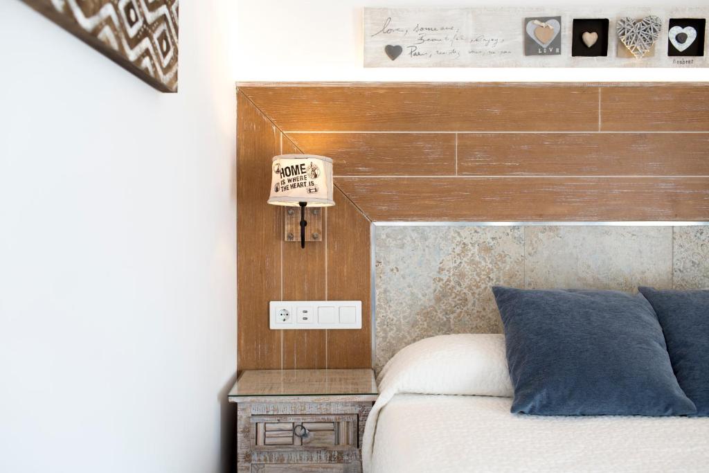 a bedroom with a bed with a wooden headboard at Hotel Plaza Cavana in Nerja