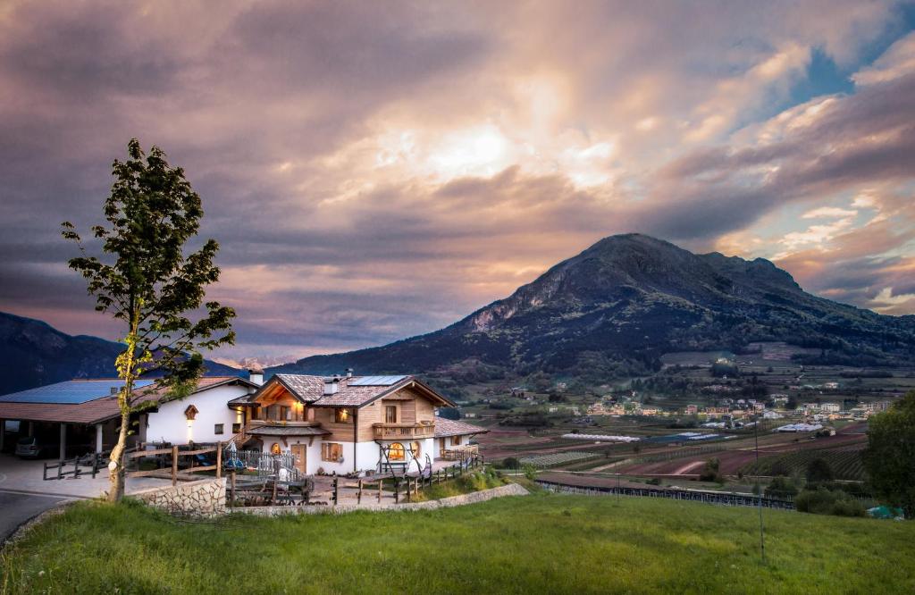 une maison sur une colline avec une montagne en arrière-plan dans l'établissement Agritur La Val, à Vigolo Vattaro