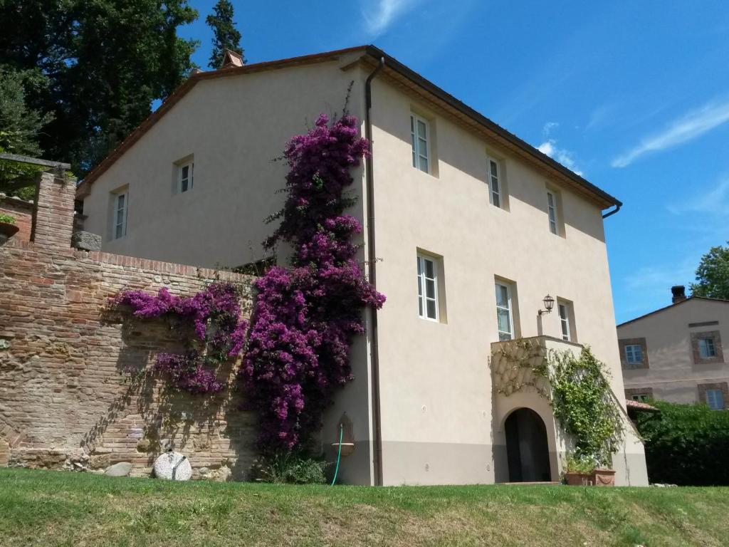 budynek z fioletowymi kwiatami na boku w obiekcie Borgo Fajani w mieście Terricciola