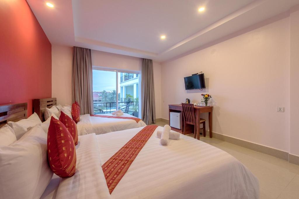 Postel nebo postele na pokoji v ubytování Golden Citadel Hotel Siem Reap