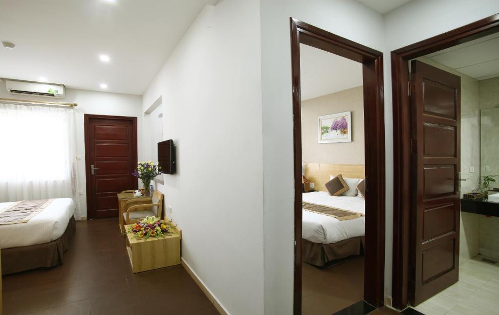 Postel nebo postele na pokoji v ubytování Blue Pearl Hanoi Hotel