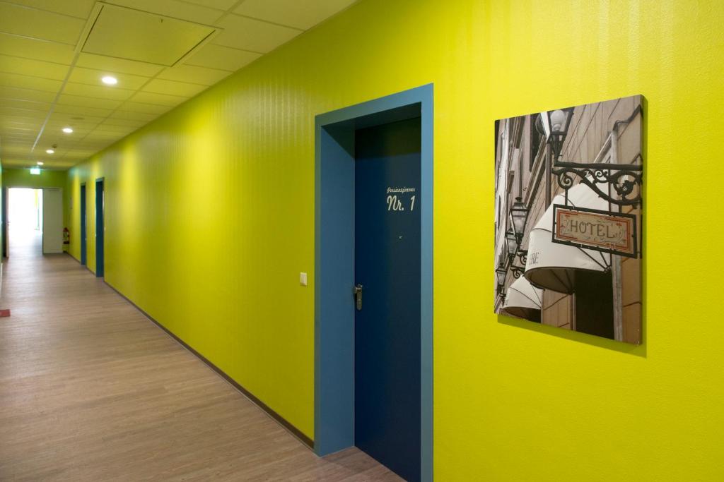 a hallway in an office with yellow and blue walls at Café & mehr in Halle an der Saale