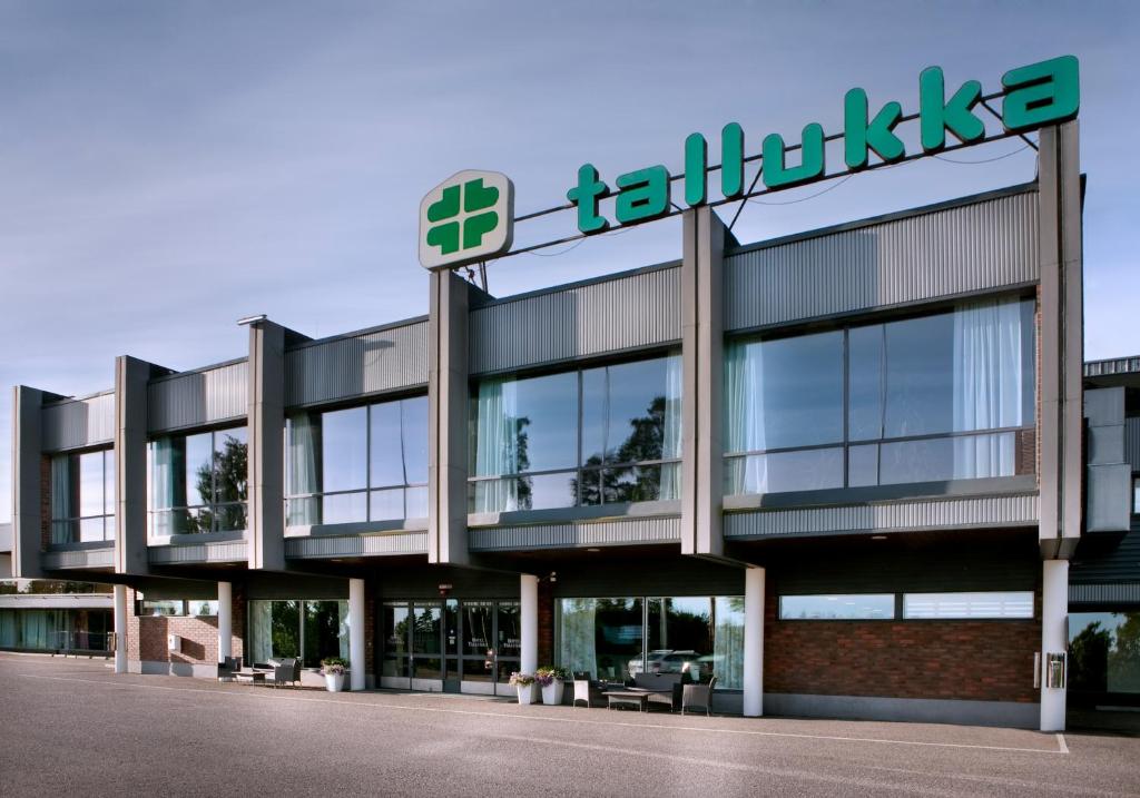 een gebouw met een bord aan de zijkant bij Hotel & Hostel Tallukka in Asikkala