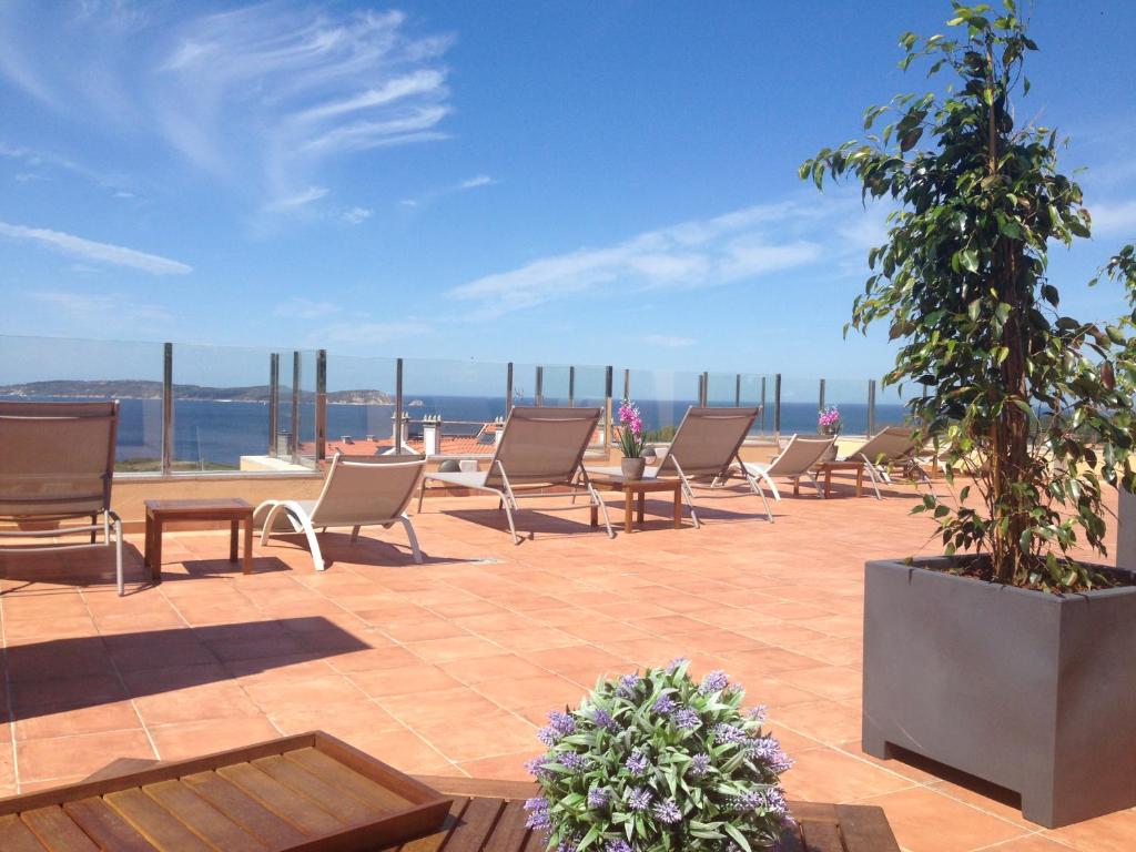 un patio con sillas y vistas al océano en Apartamentos Aqualecer, en Aios