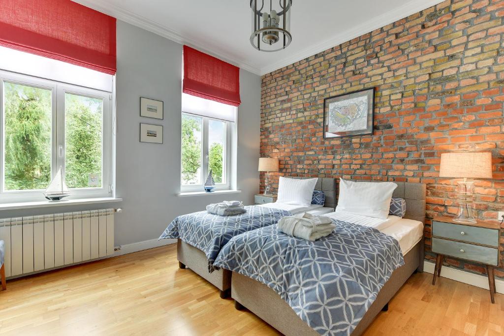 sypialnia z ceglaną ścianą i łóżkiem w obiekcie Lion Apartments - Hampton Family Apartment with two bedrooms w mieście Sopot