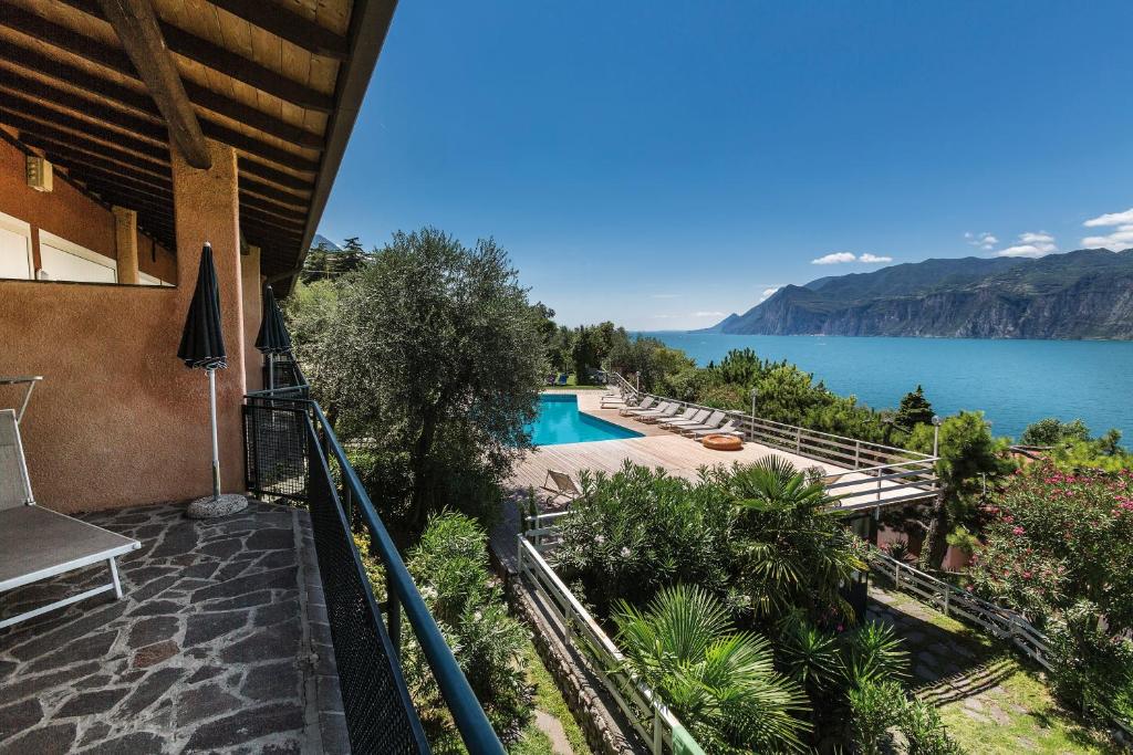 a house with a swimming pool and a view of the water at Residence Parco Lago di Garda in Malcesine