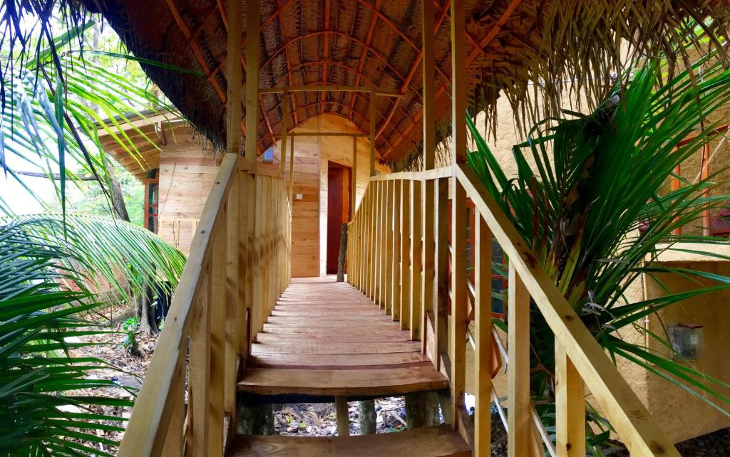 Una pasarela de madera que conduce a una casa con una escalera en Seasons Four Eco Friendly Treehouse, en Matara