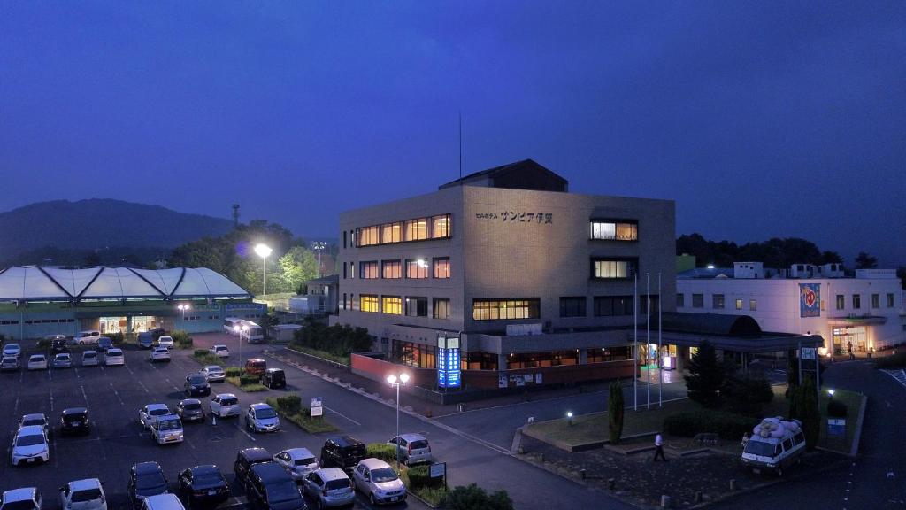 a parking lot in front of a building at night at Hill Hotel Sunpia Iga in Iga