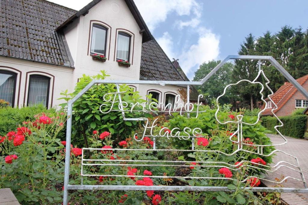 a garden with red flowers in front of a house at Landhaus Zur Eiche in Sittensen