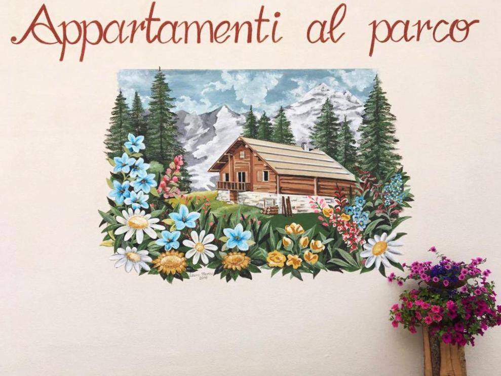 a painting of a cabin with flowers on a wall at Appartamenti al Parco in Molveno