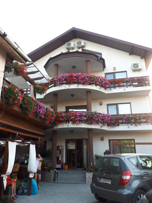 a building with a balcony with flowers on it at Pensiunea Daiana in Mamaia Nord
