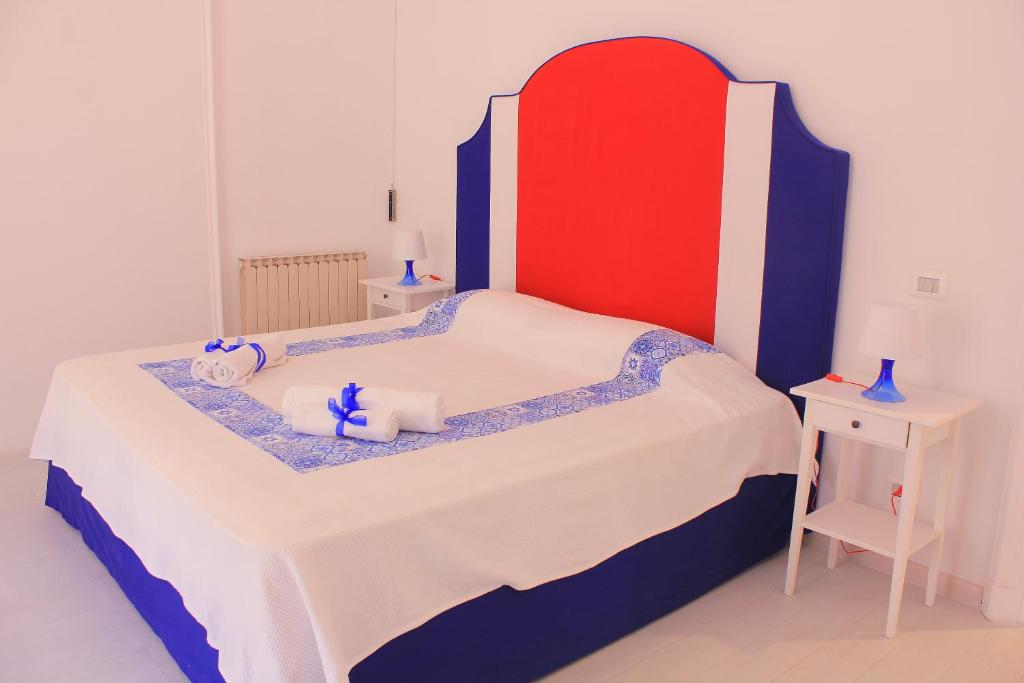 フォルミアにあるB&B Vitruvio Suitesのベッドルーム1室(赤と青のヘッドボード付きのベッド1台付)