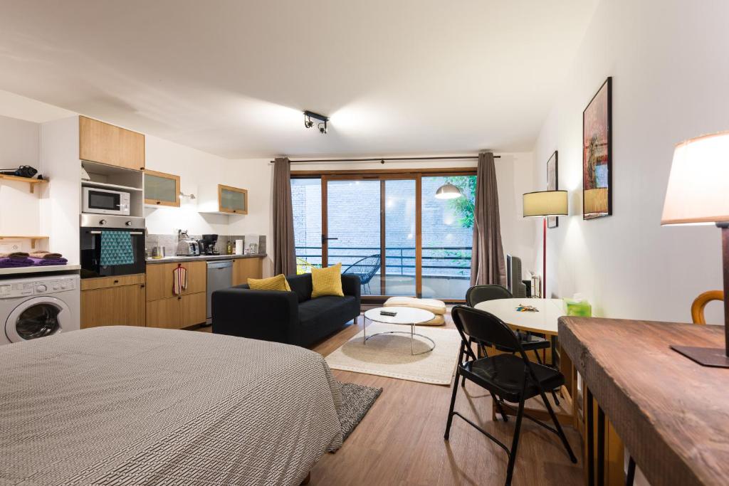 een kamer met een bed en een woonkamer met een keuken bij Studio du musée in Lille