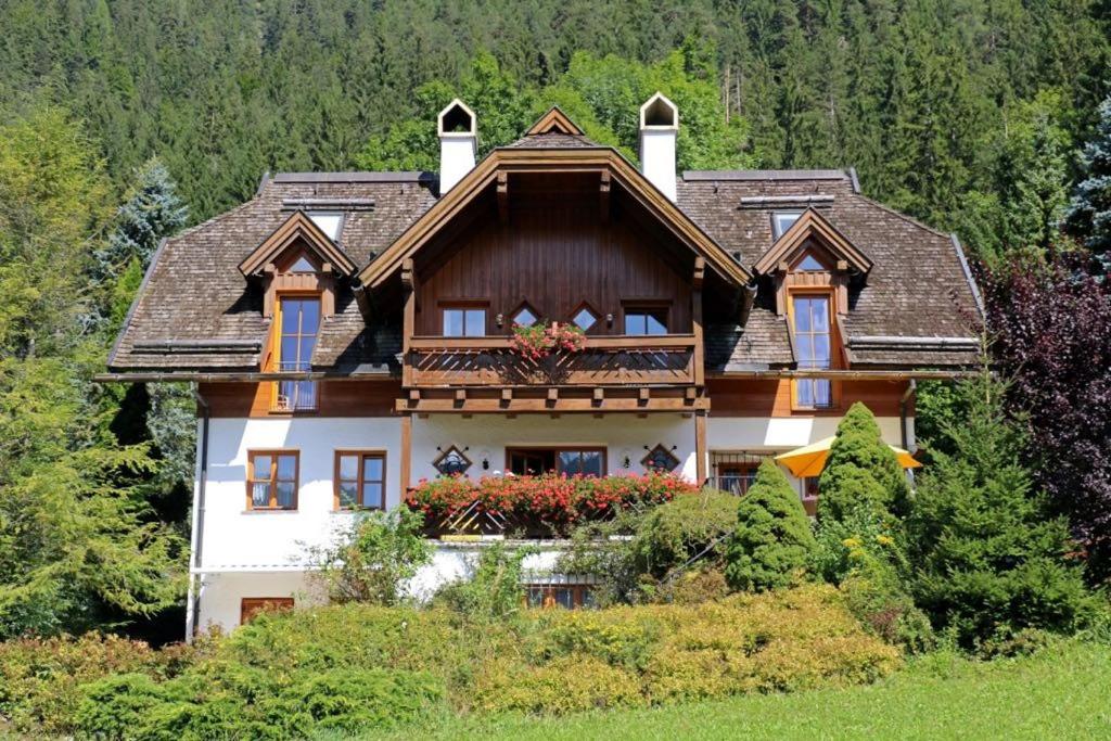 una casa en la cima de una colina con árboles en Landhaus Sonneck en Weissensee