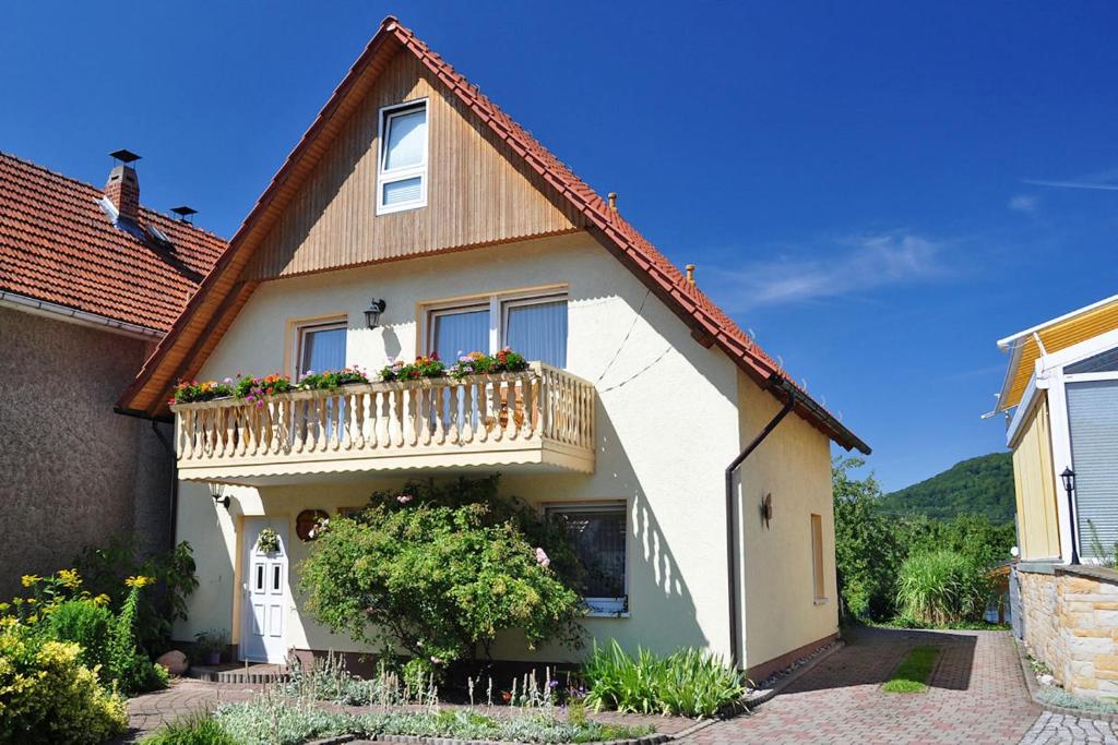 a house with a balcony with flowers on it at Pension "AM RENNSTEIG" in Eisenach