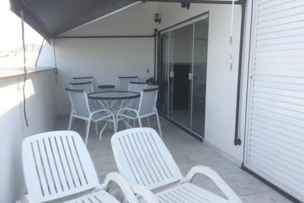 un patio con sillas blancas, mesa, mesas y sillas en COPA, COBERTURA, DOIS QUARTOS, TERRAÇO E VARANDA, POSTO 3, en Río de Janeiro