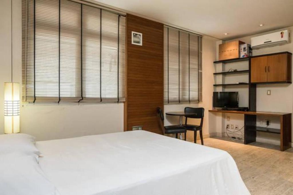 1 dormitorio con 1 cama blanca grande y escritorio en Perto de Ipanema, 250 metros da praia, entre postos 5 e 6, en Río de Janeiro