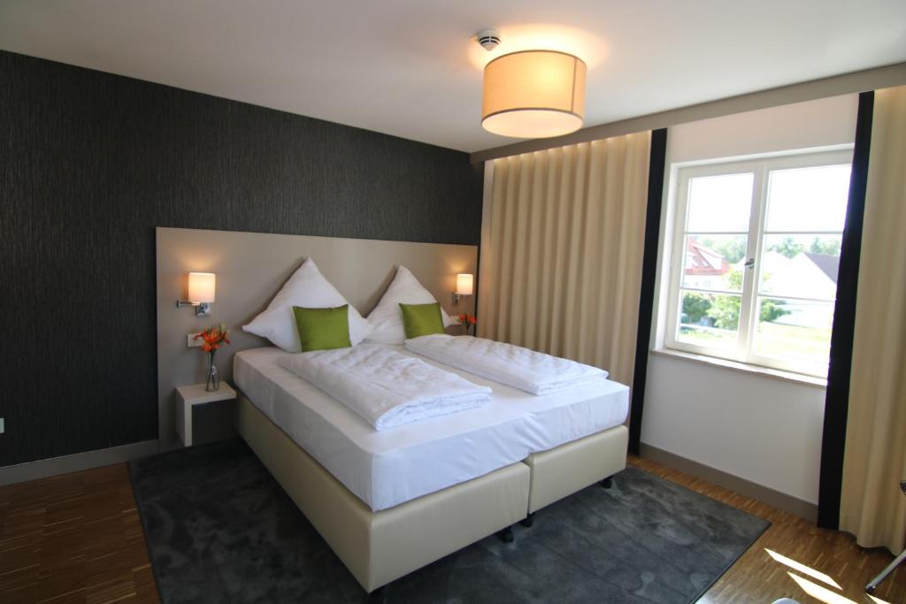 ein Schlafzimmer mit einem großen weißen Bett und einem Fenster in der Unterkunft BA Hotel by WMM Hotels in Babenhausen