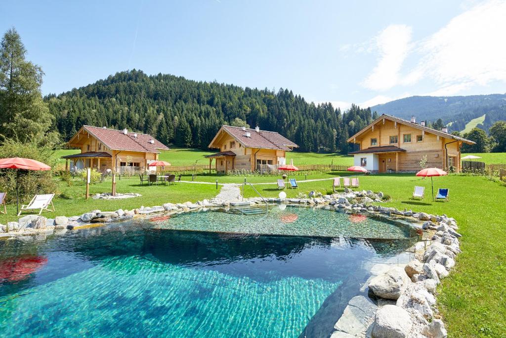 a large swimming pool in a yard with a house at Lehenriedl Chalet in Wagrain