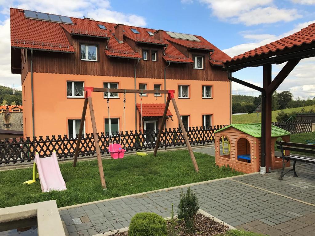 duży budynek z placem zabaw przed nim w obiekcie Pokoje Gościnne w Dolinie Szczęścia w Szklarskiej Porębie
