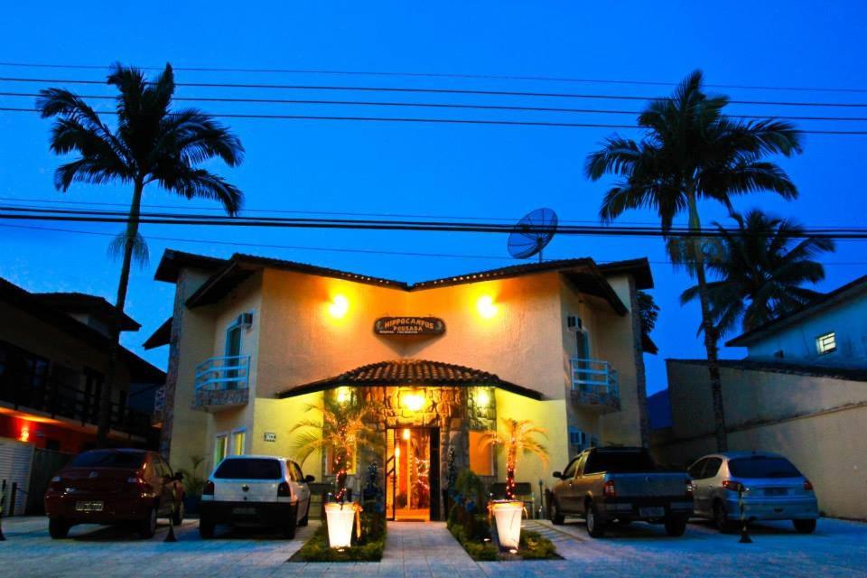 a hotel with cars parked in front of a building at Pousada Hippocampus in Juquei