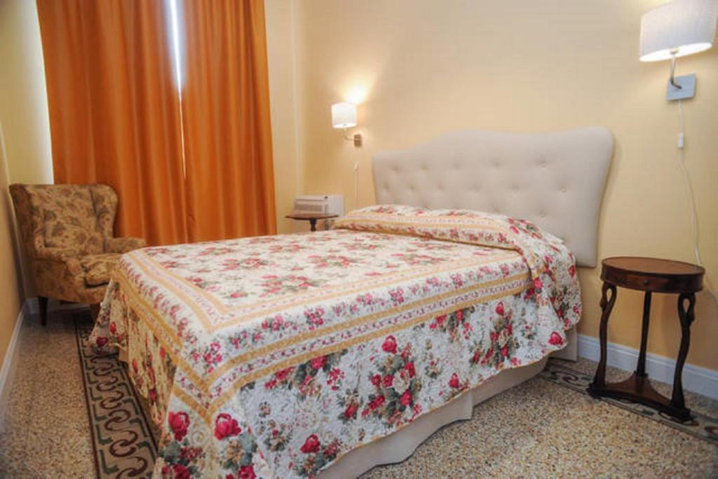 フィレンツェにあるResidenza Arrivabeneのベッドと椅子付きのホテルルーム