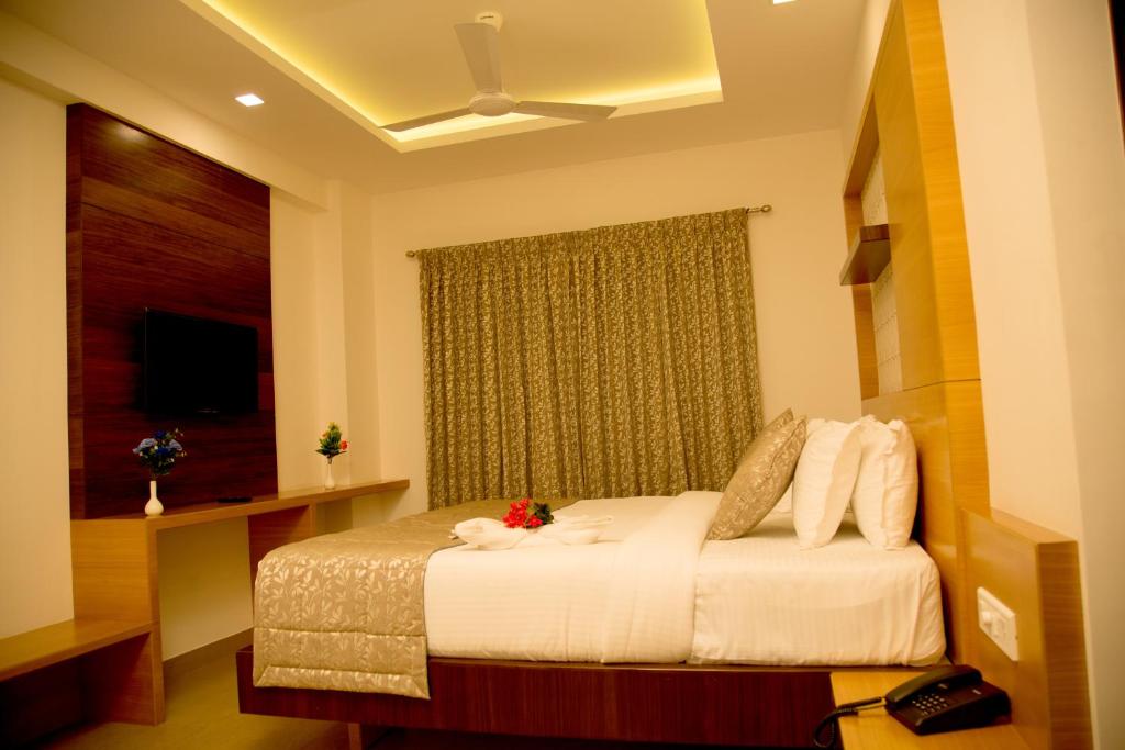 a hotel room with a bed and a window at Hotel Grand Tree in Coimbatore