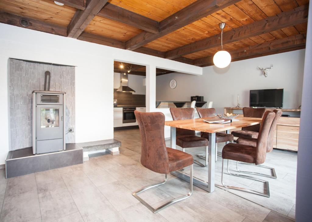 a dining room with a table and chairs and a fireplace at Margaritenweg 31-F, Winterberg-Niedersfeld in Winterberg