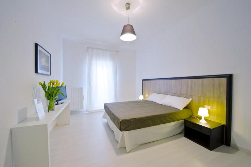 een slaapkamer met een bed in een witte kamer bij Vico Amato Residenza in Sulmona