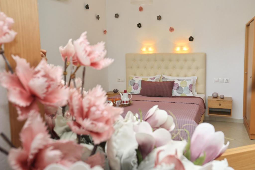 a bedroom with a bed with pink flowers in the foreground at Kastoria Hotel Apartments in Hanioti