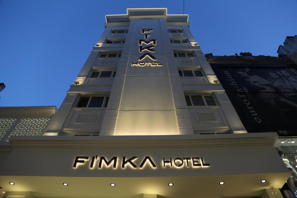 イスタンブールにあるFimka Hotelの建物の上に看板のあるホテル