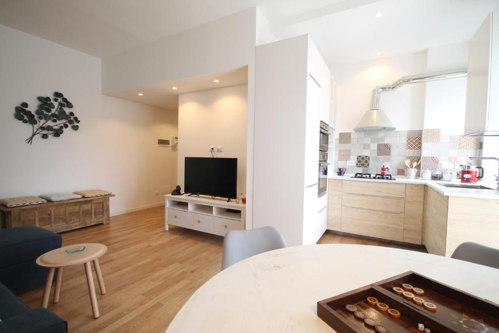 a kitchen and living room with a table and a tv at House of Mirrors in Milan