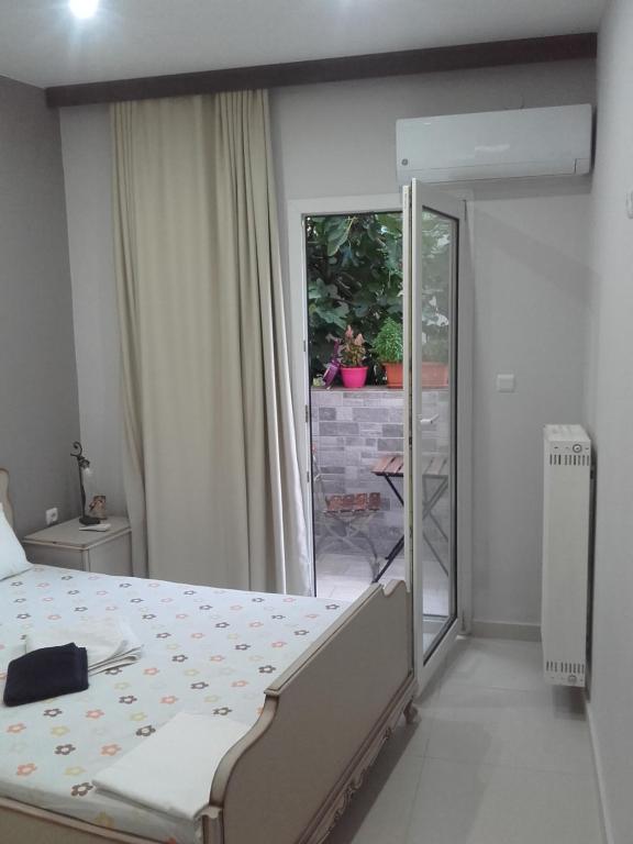 1 dormitorio con 1 cama y puerta corredera de cristal en Errica Apartment en Preveza