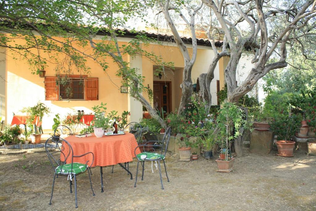 una mesa y sillas frente a una casa en B&B Villa Calagioli, en Castelbuono