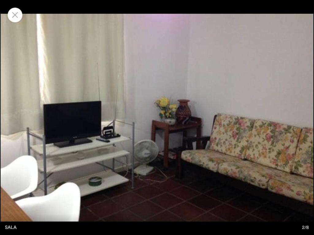 een woonkamer met een bank en een flatscreen-tv bij Guaruja próximo a praia Enseada in Guarujá