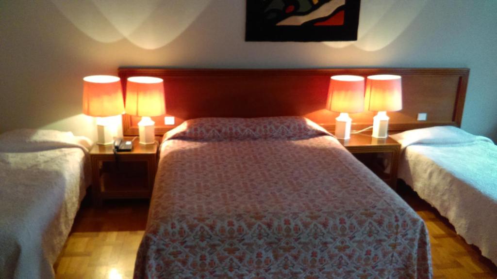 a bedroom with two beds with lamps on them at Hotel de l&#39;Orangerie in Strasbourg