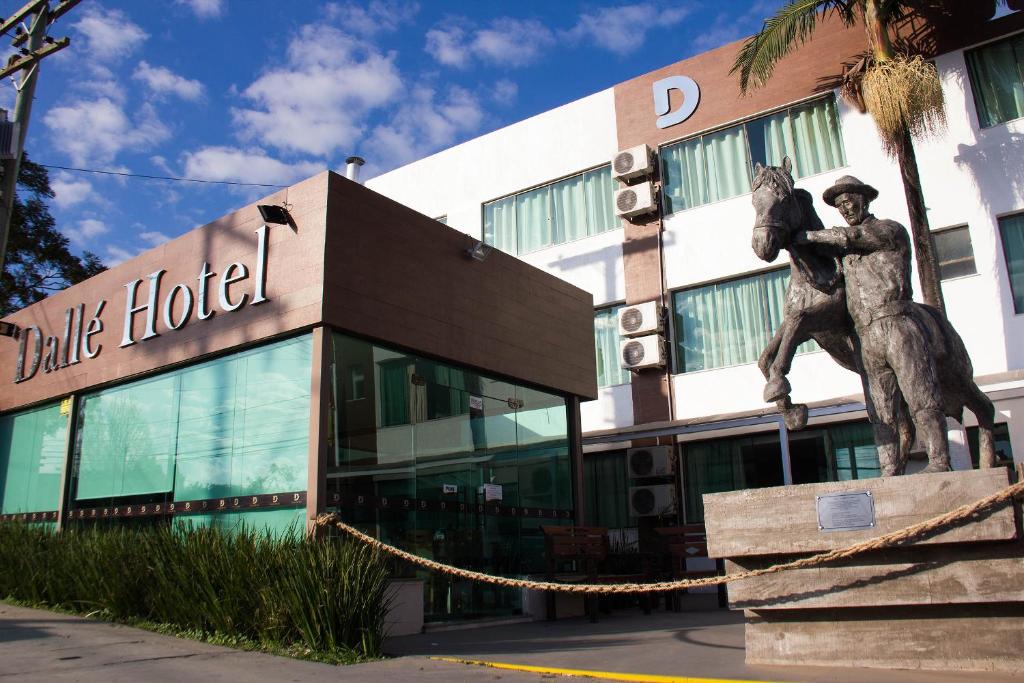 a statue of a man riding a horse in front of a building at Dalle Hotel in Bagé