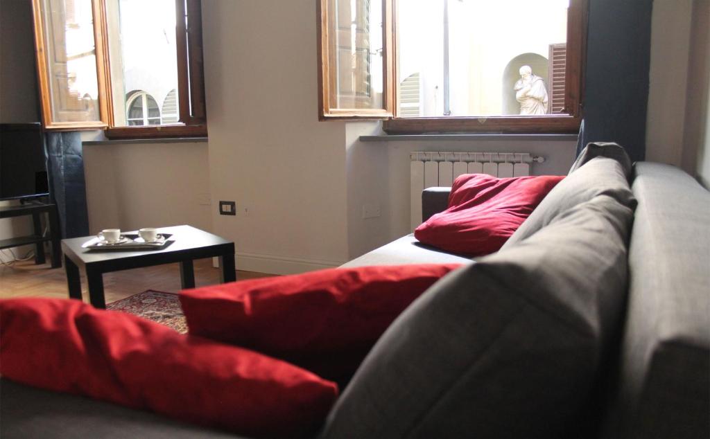 - un salon avec des oreillers rouges sur un canapé dans l'établissement Duomo Classic Apartment, à Florence