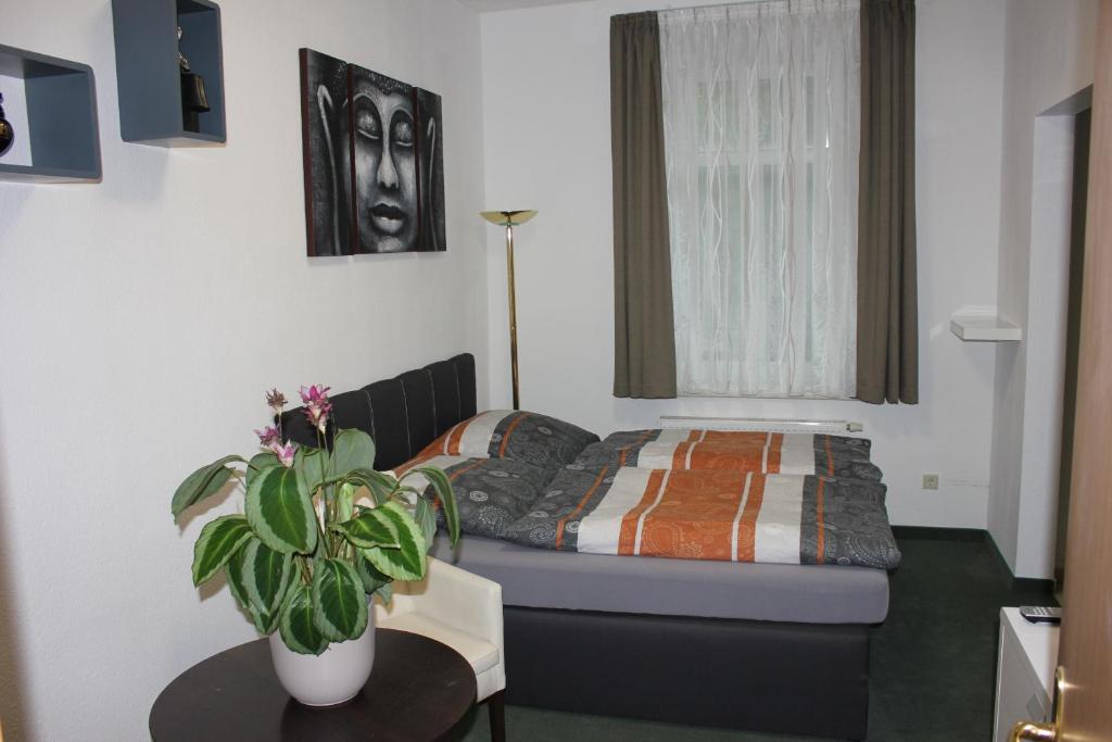 a small bedroom with a bed and a table at Ferienwohnung Bonita in Freital