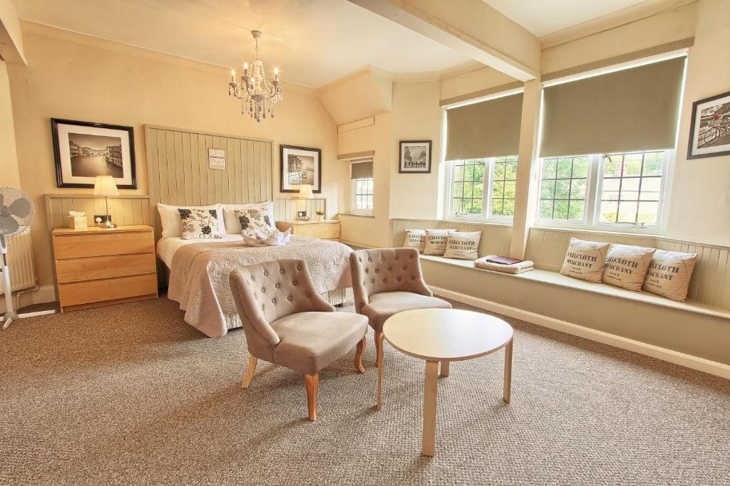 a bedroom with a bed and a chair and a table at The Stockton Arms Hotel in Stockton-on-Tees