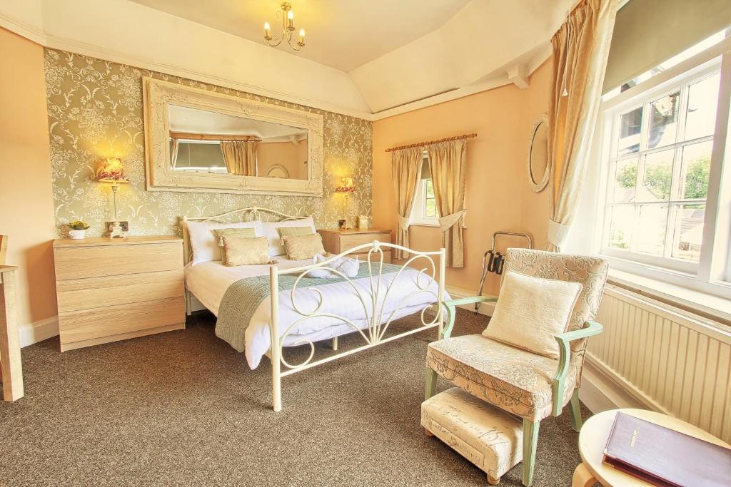 una camera da letto con un letto, uno specchio e una sedia di The Stockton Arms Hotel a Stockton-on-Tees