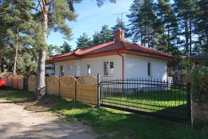 mały dom z płotem przed nim w obiekcie Słoneczny Dom w Poddąbiu