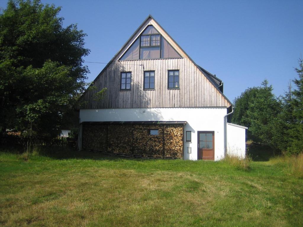 un granero blanco grande con techo de gambrel en Ferienhaus Zinnwald en Kurort Altenberg