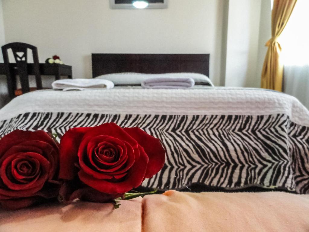 Postel nebo postele na pokoji v ubytování Hostal La Rosa Otavalo