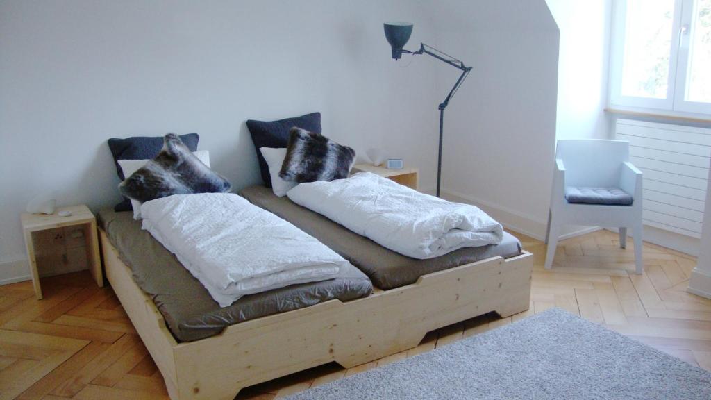 a bed with pillows on it in a room at B&B Laupenring, Basel in Basel