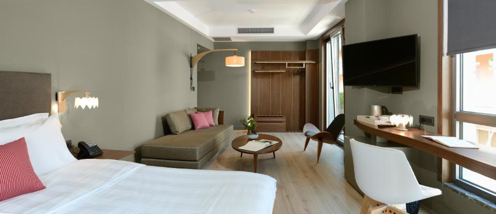 a living room filled with furniture and a tv at Lake Spirit Boutique Hotel & Spa in Ioannina