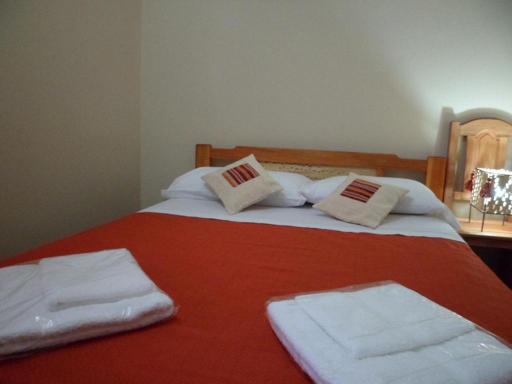 Un dormitorio con una cama con toallas blancas. en El Cardon Hospedaje en Huacalera