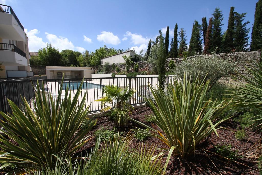 einen Garten mit Pflanzen vor einem Zaun in der Unterkunft Alpilles Villa Serena in Saint-Rémy-de-Provence