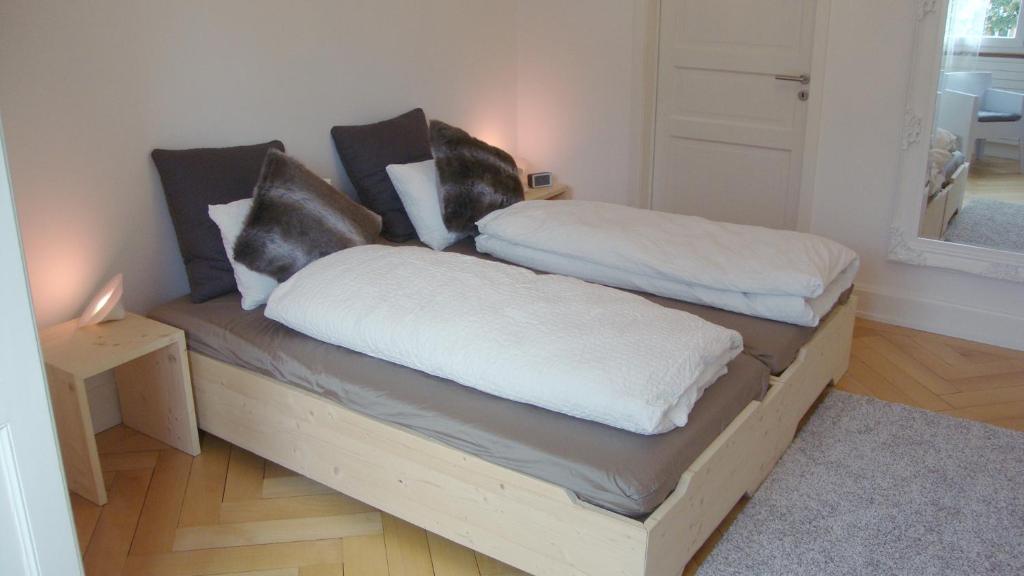 two pillows on a wooden couch in a room at B&B Laupenring, Basel in Basel